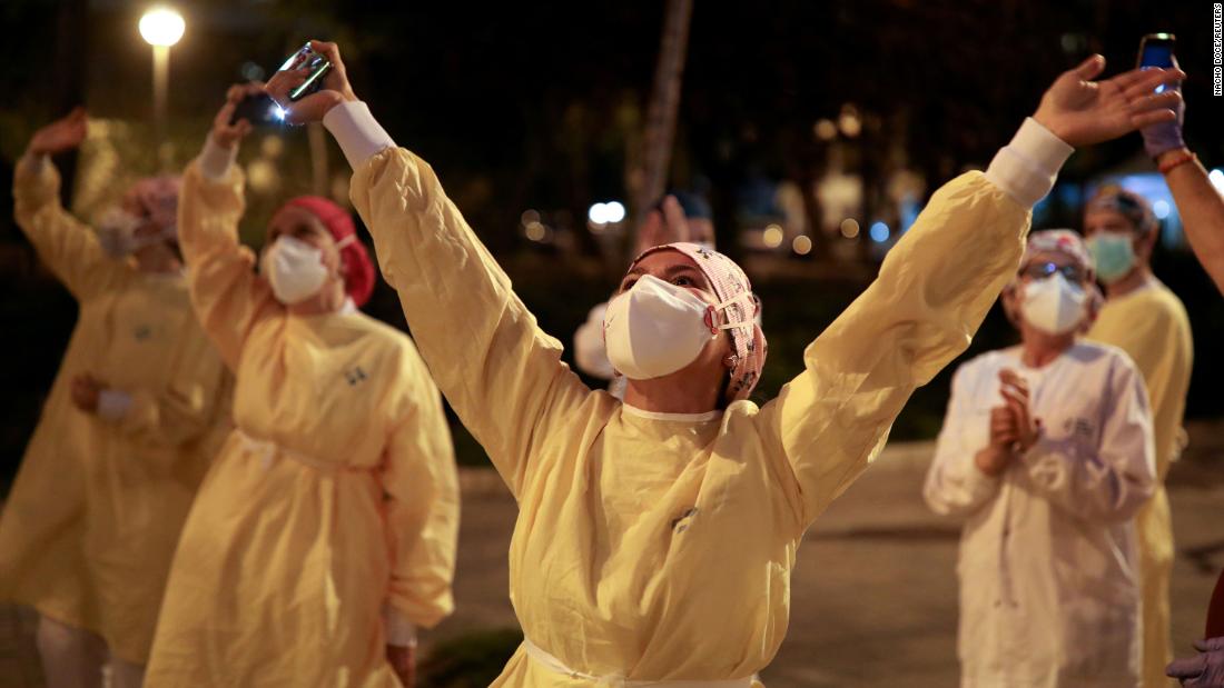 Health workers in Barcelona, Spain, acknowledge people who were showing their support from their balconies and windows.